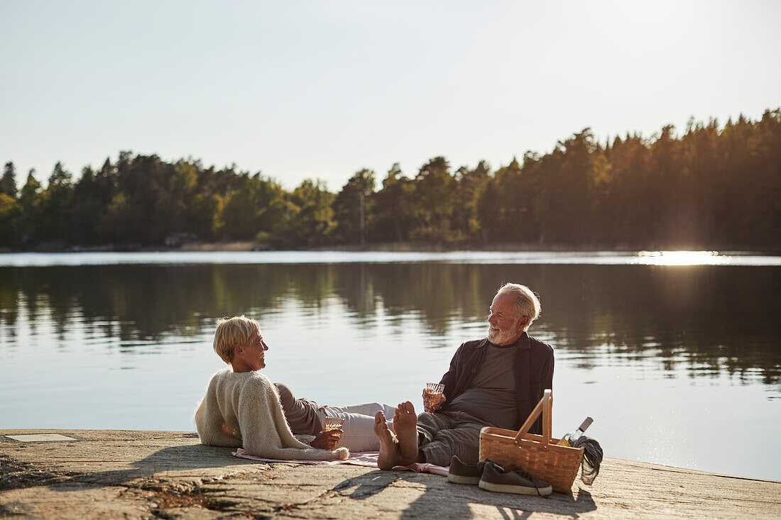 Smiling couple having picnic at lake