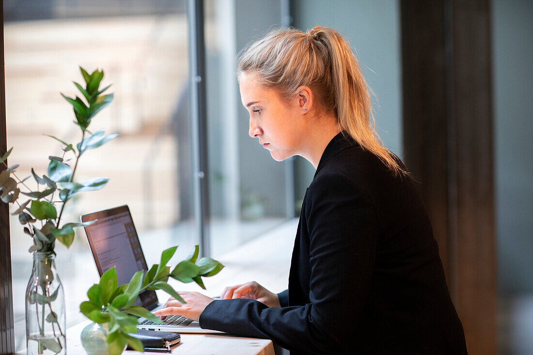 Businesswoman using laptop in cafe