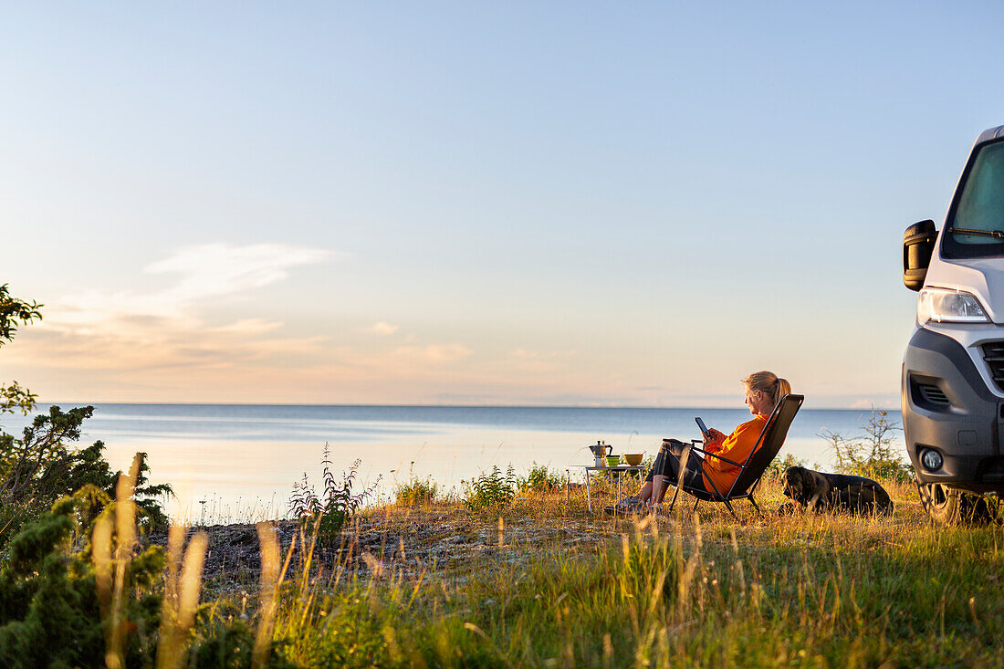 Frau entspannt auf Liegestuhl am Meer