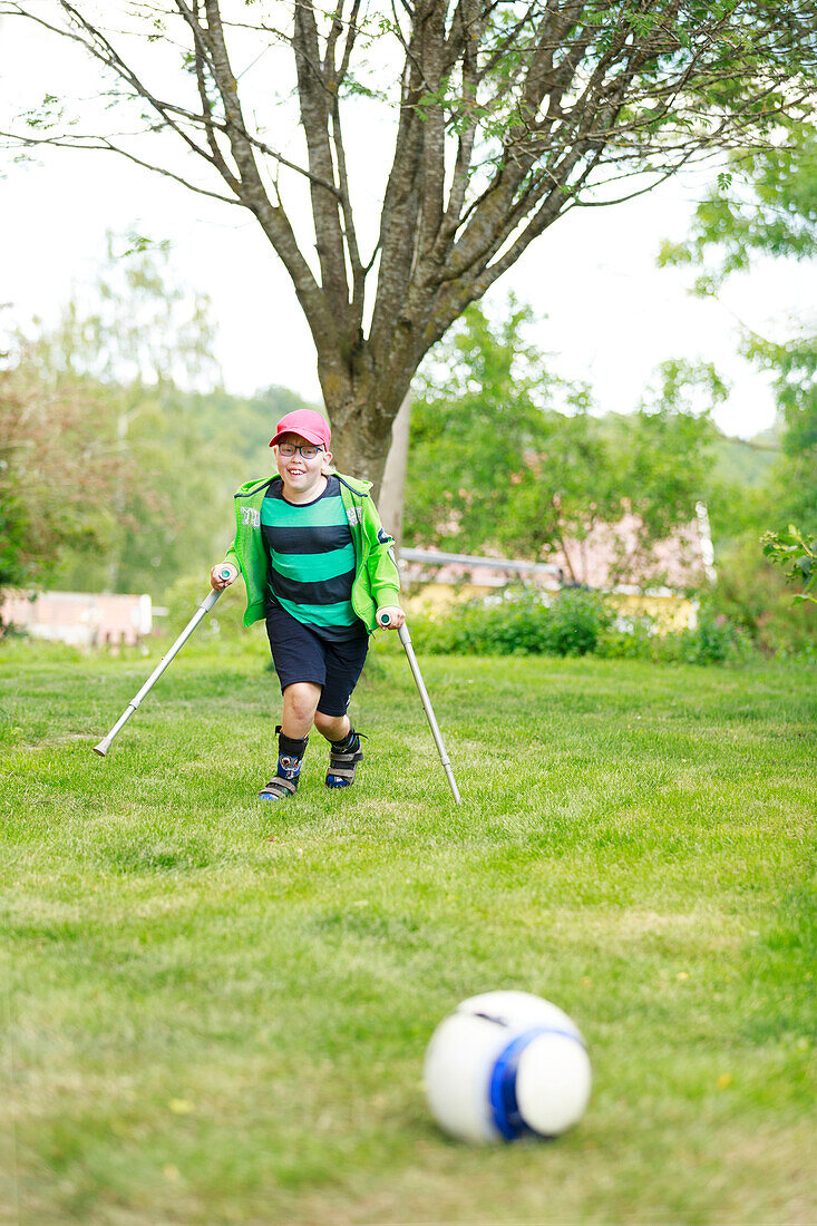 Junge spielt Fußball im Garten