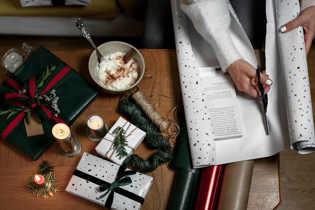 Frauenhände verpacken Weihnachtsgeschenk