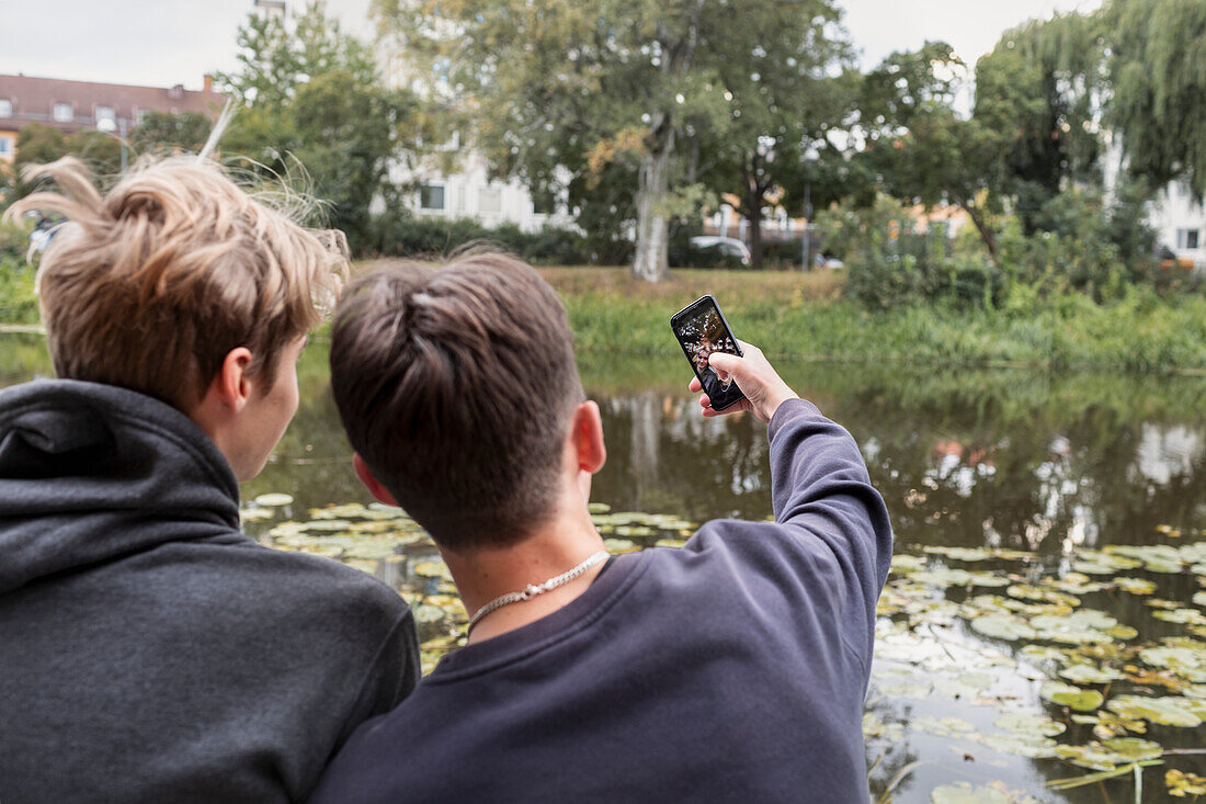 Rear view of two teenage boys taking selfie