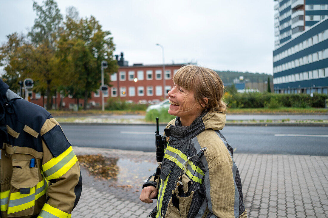 Glücklicher weiblicher Feuerwehrmann schaut weg