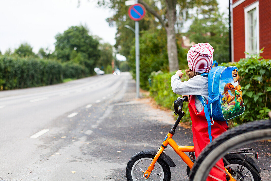 Mädchen hält Fahrrad an der Straße