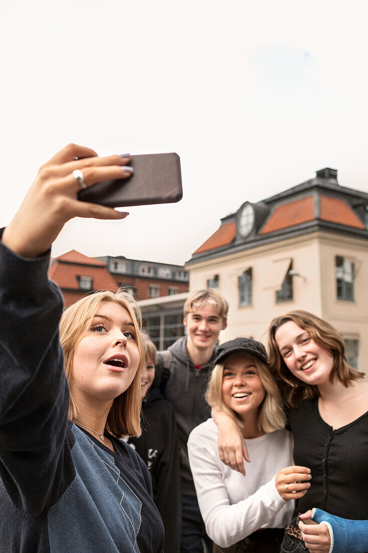 Smiling teenagers taking selfie