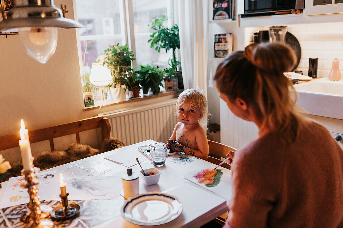 Mother and toddler painting at table