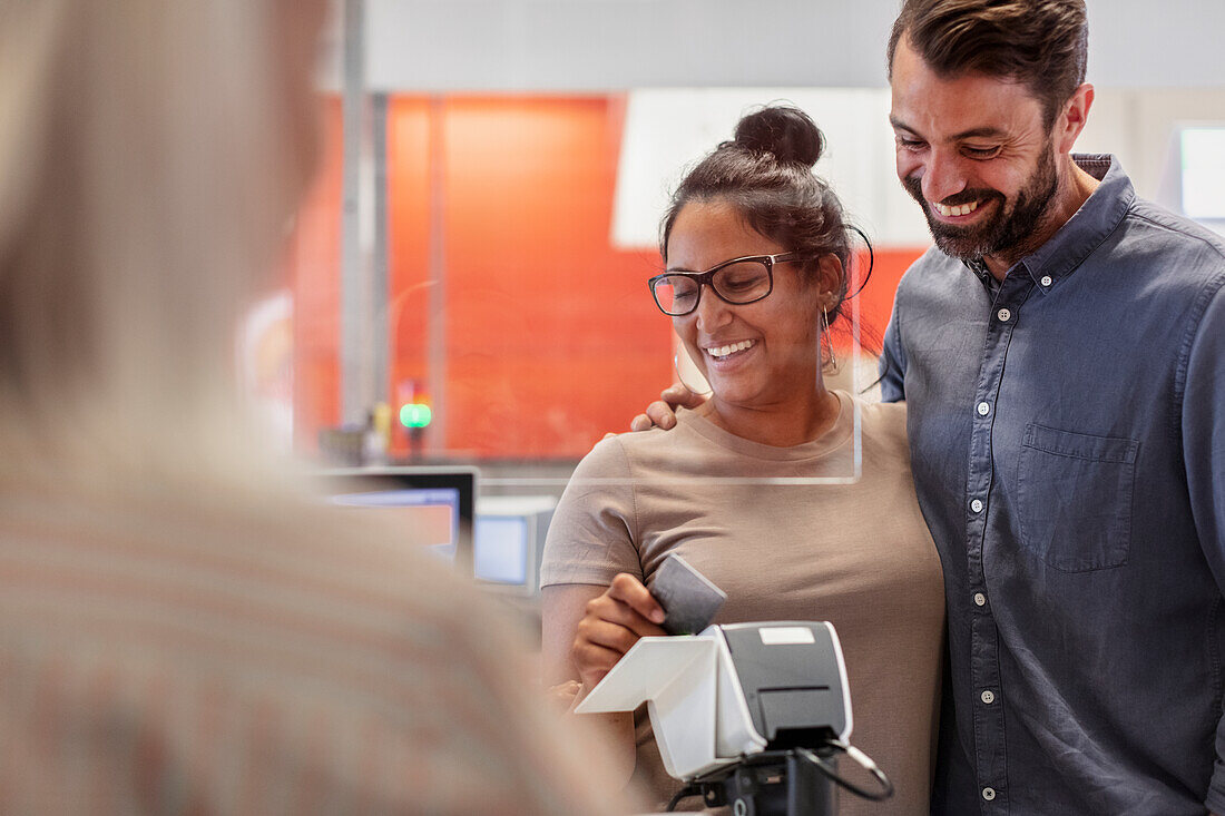 Smiling couple paying at till