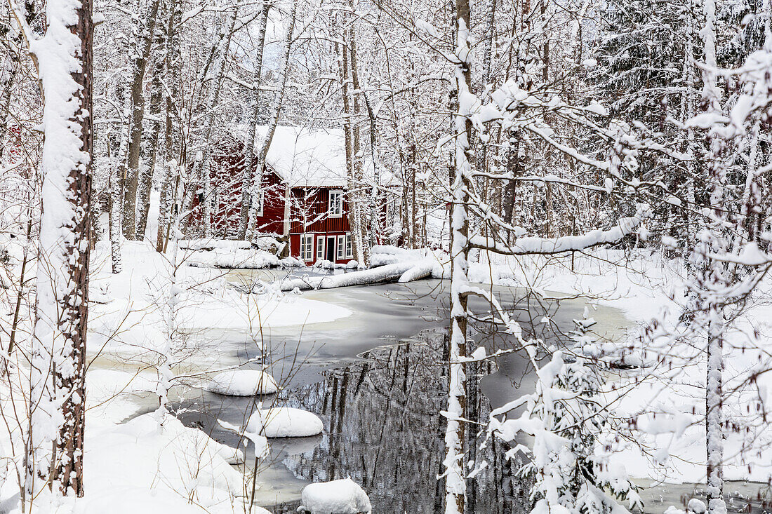 Winter landscape with wooden house at river