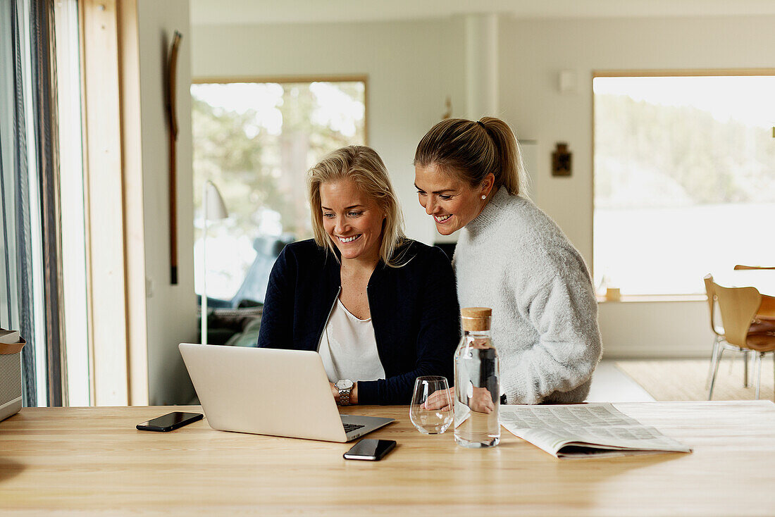 Zwei Frauen, die zu Hause mit dem Laptop arbeiten