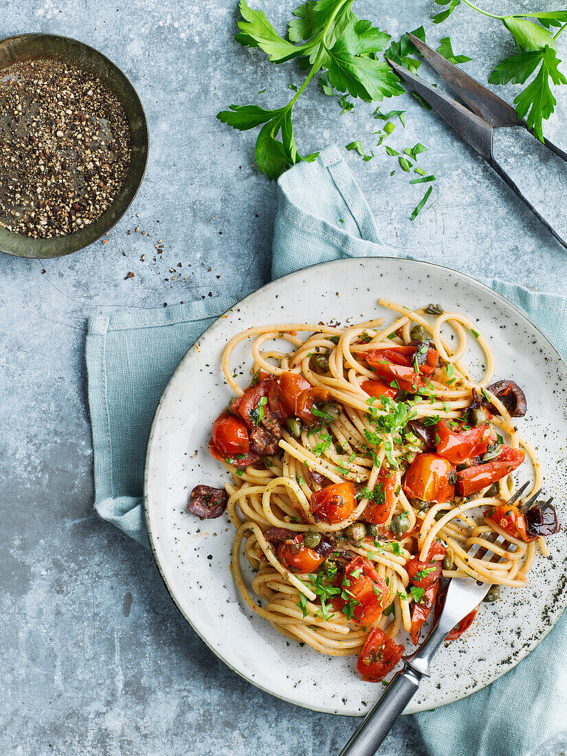 Spaghetti mit Tomaten und Oliven auf einem Teller