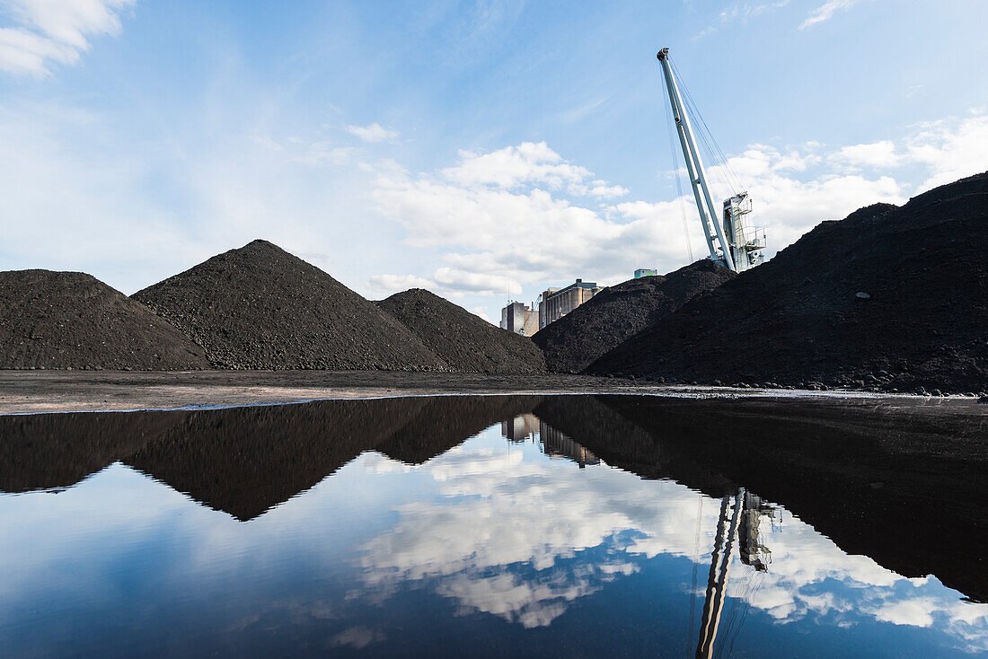 Piles of gravel reflecting in water