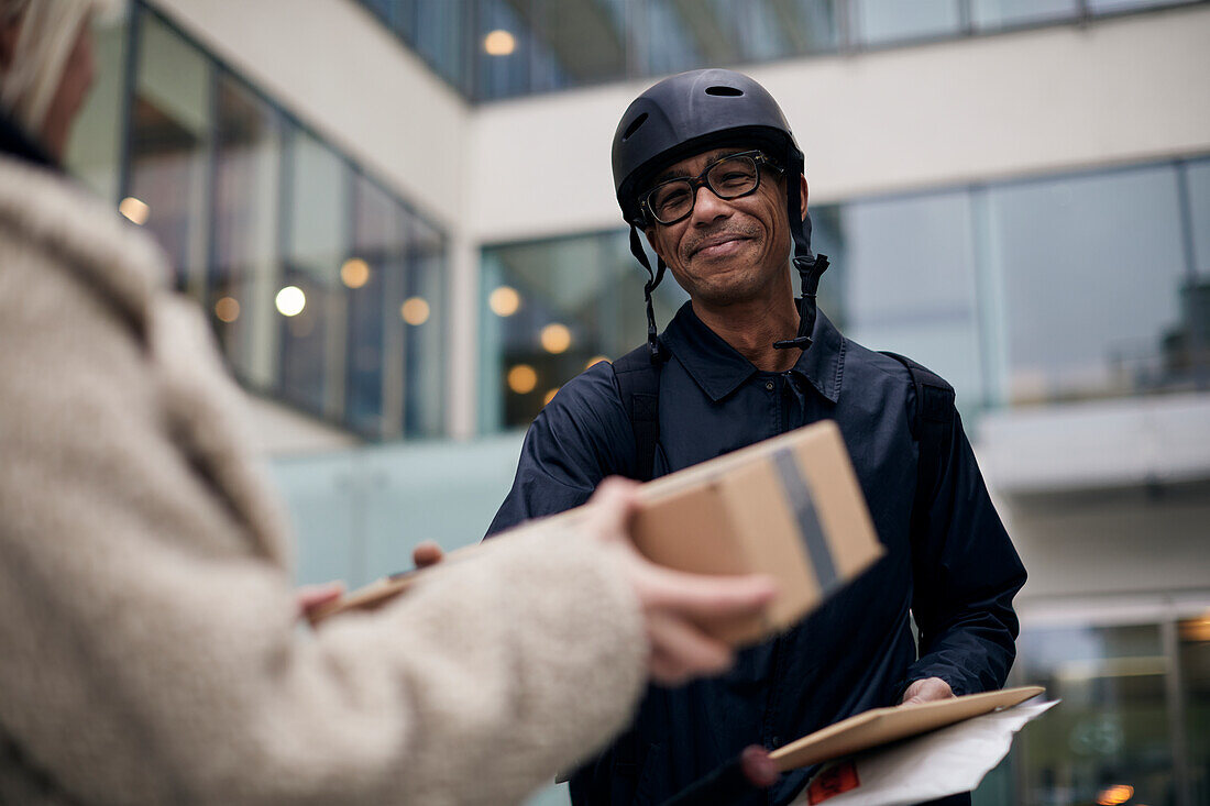 Fahrradkurier bei der Auslieferung eines Pakets an einen Kunden