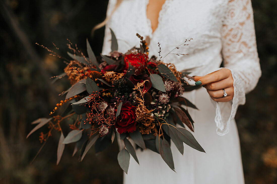 Mid section of bride holding wedding bouquet