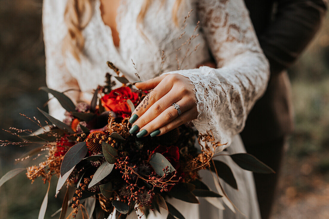 Mid section of bride holding wedding bouquet