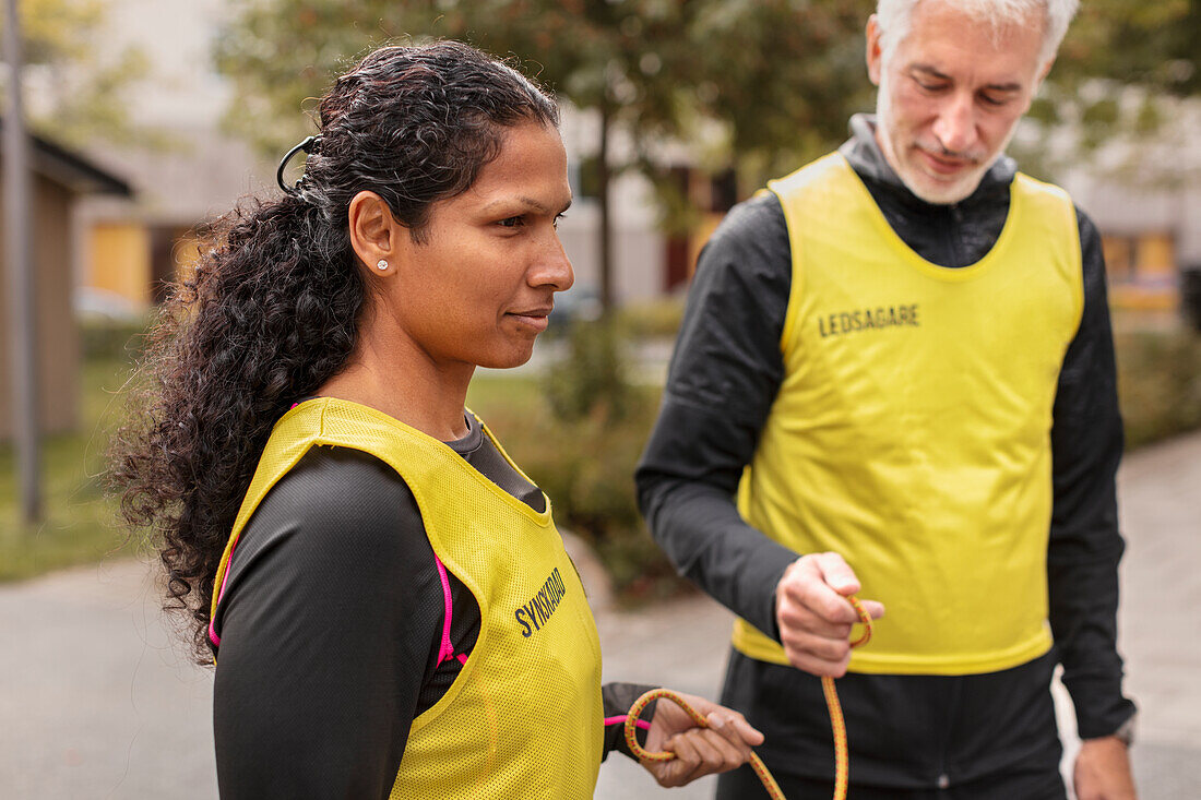 Visually impaired woman preparing for jogging with guide runner