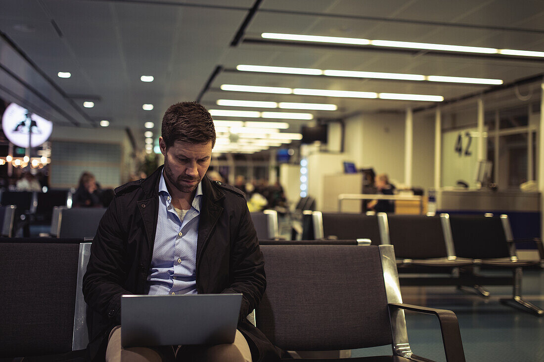 Businessman at airport using laptop