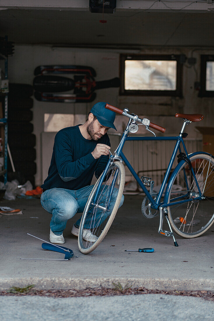 Man repairing bicycle in garage