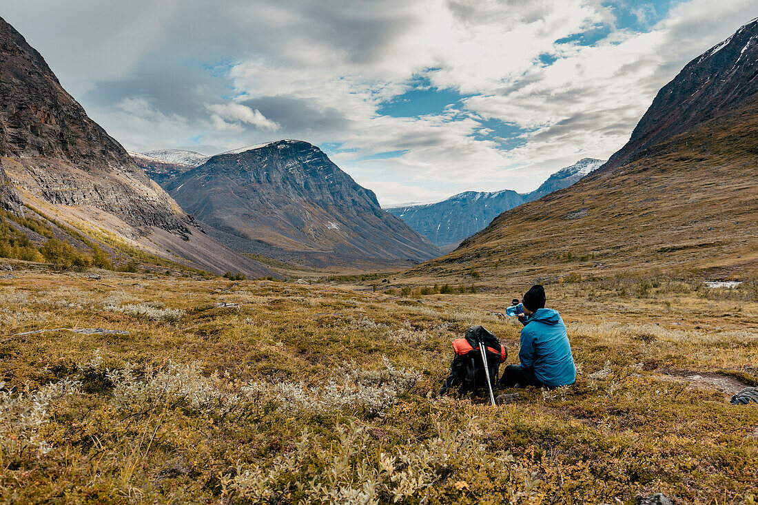 Rear view of hiker resting in mountains