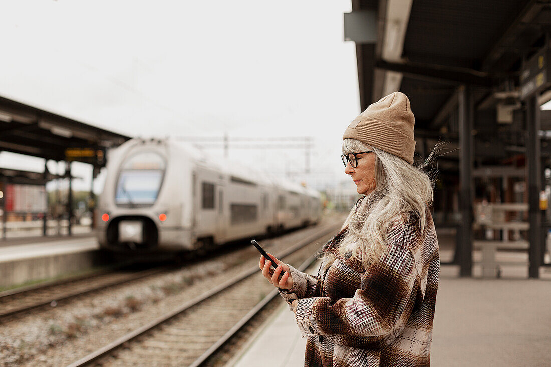 Reife Frau am Bahnhof