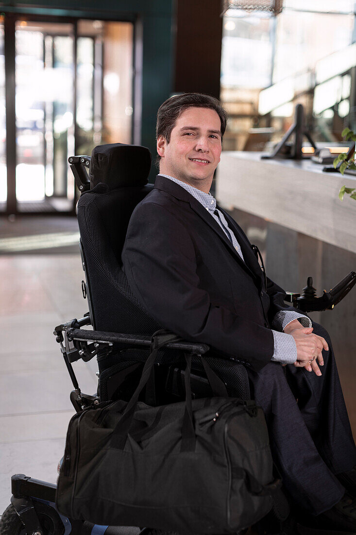Geschäftsmann im Rollstuhl in der Hotellobby