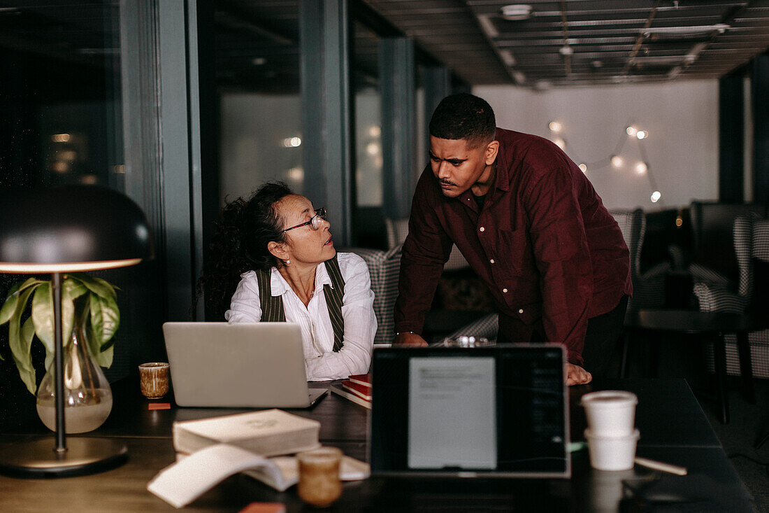 Man and woman in office at night