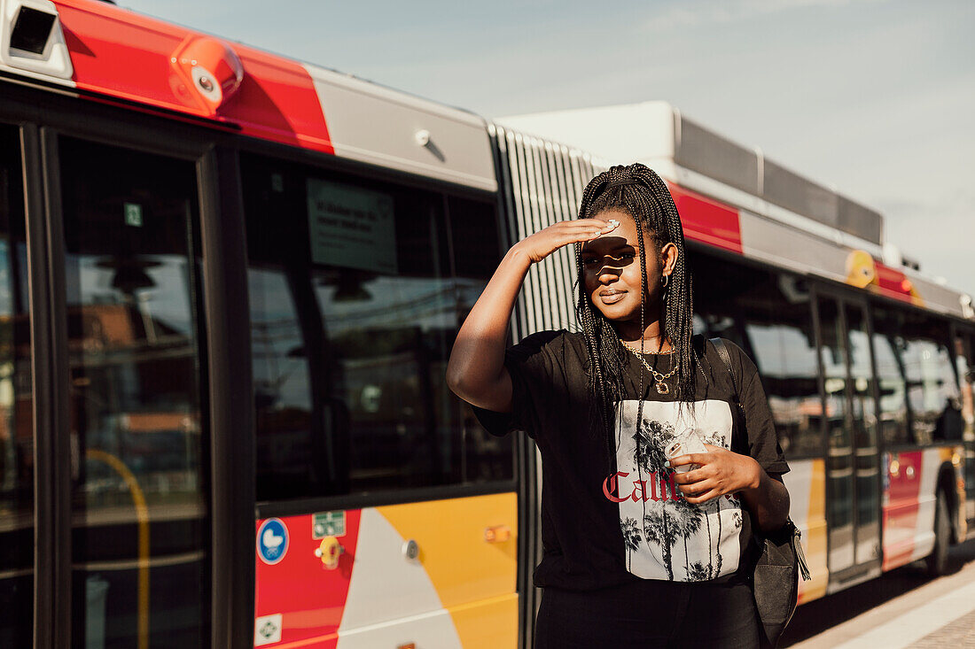 Junge Frau wartet am Busbahnhof