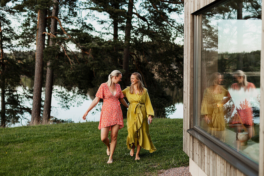 Smiling female friends walking in backyard