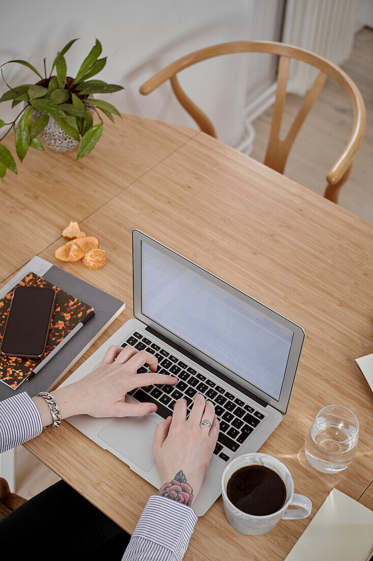 High angle view of hands using laptop