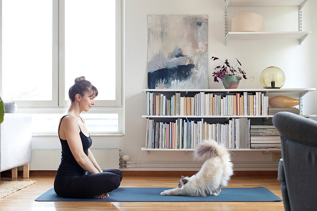Frau mit Katze auf Yogamatte