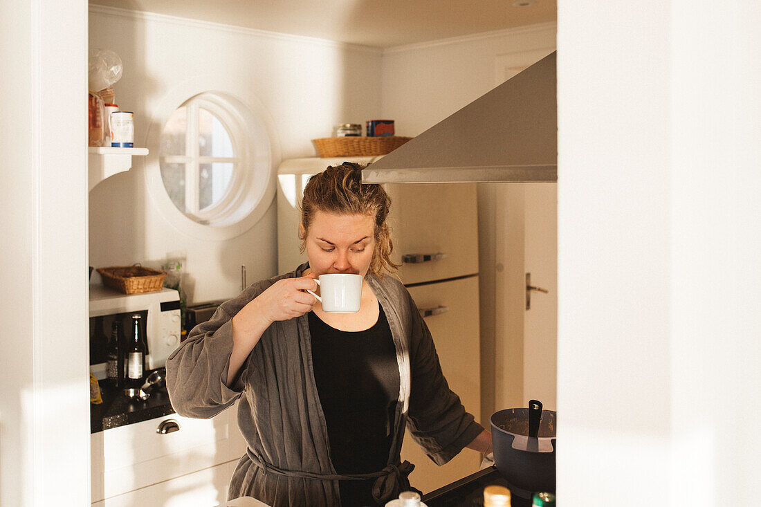 Woman drinking coffee in kitchen