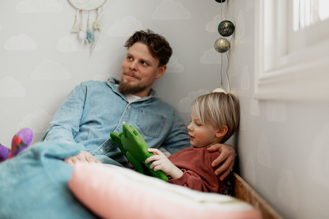 Vater mit Sohn benutzt digitales Tablet