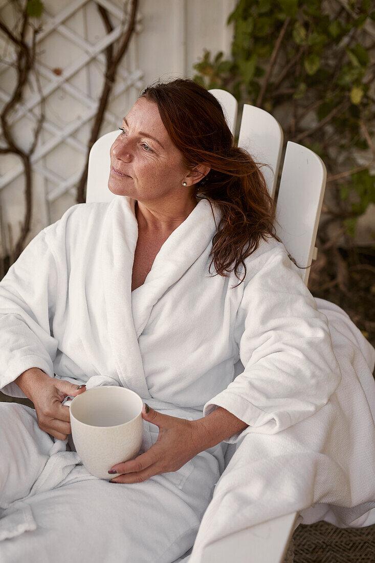 Frau trinkt Kaffee im Garten