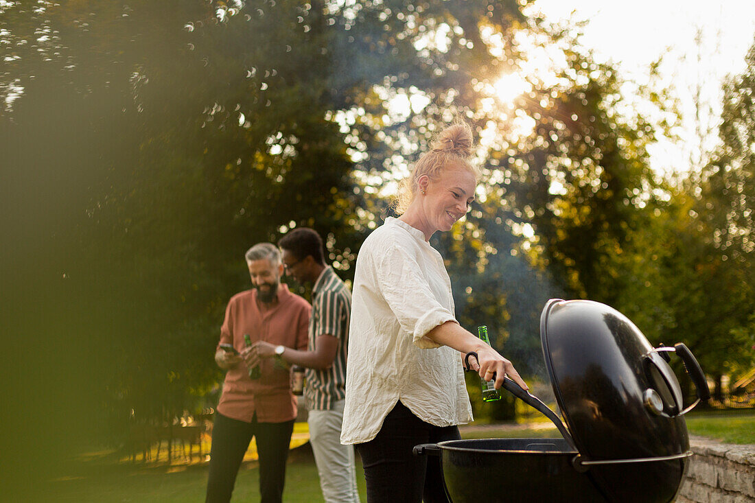 Lächelnde Frau bei der Zubereitung von Essen am Grill