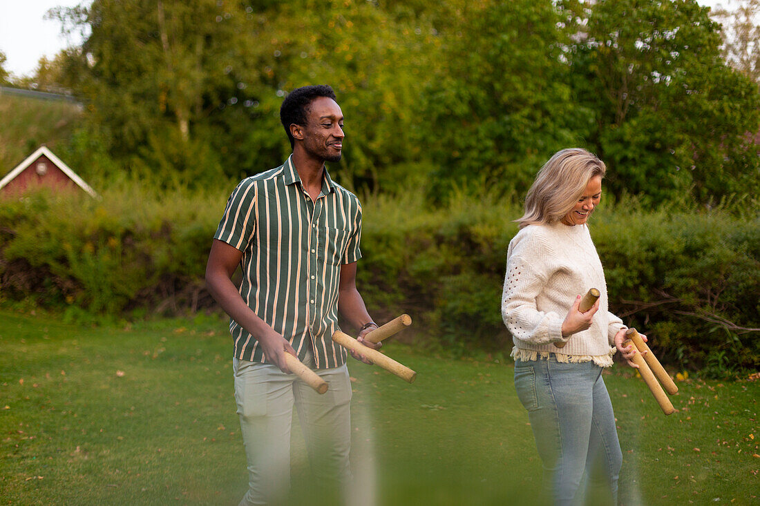 Man and woman playing molkky game in park