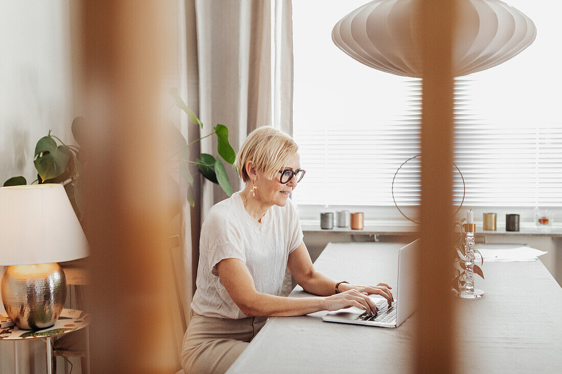 Frau benutzt Laptop zu Hause