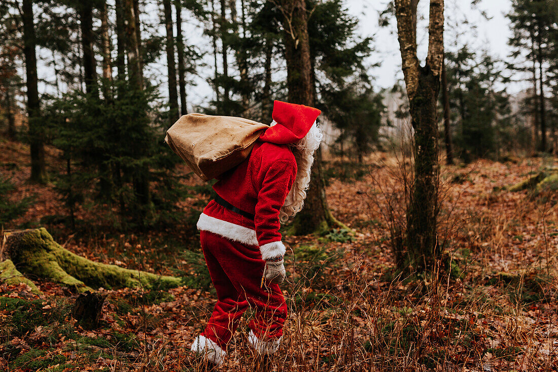 Man wearing Santa costume carrying sack