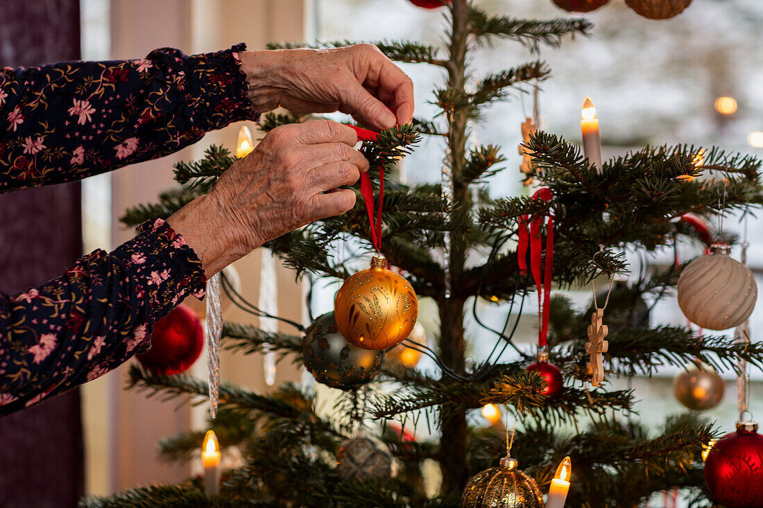 Woman's hands decorating Christmas tree