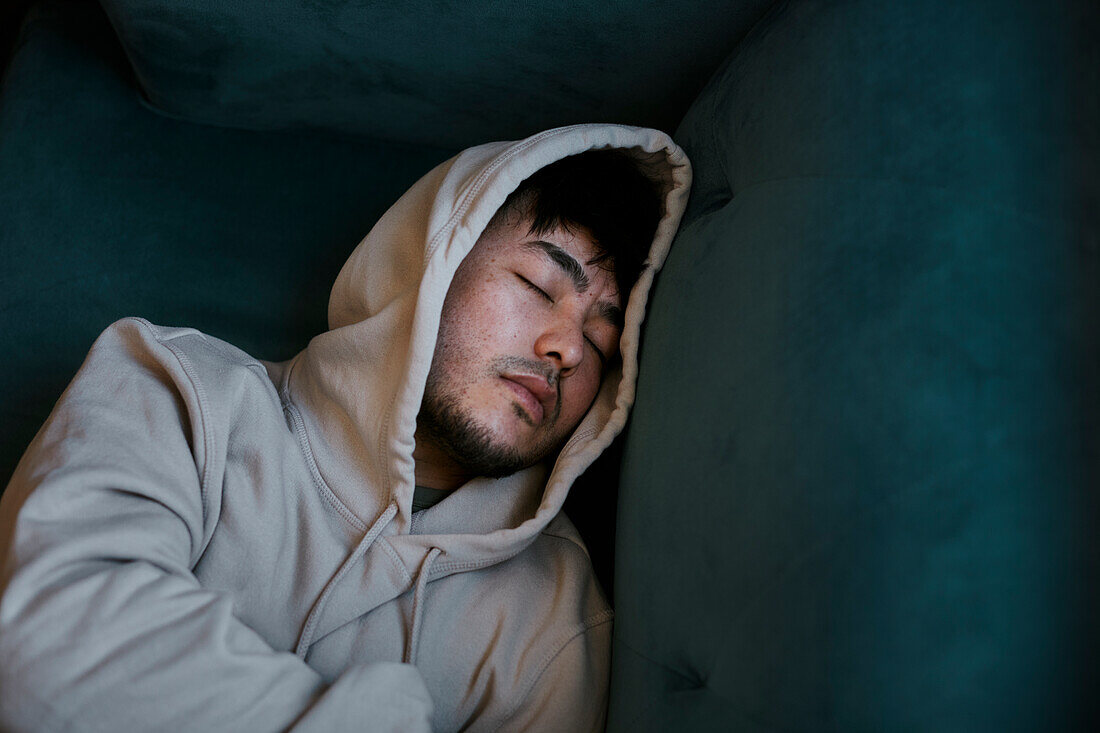 High angle view of man sleeping on sofa