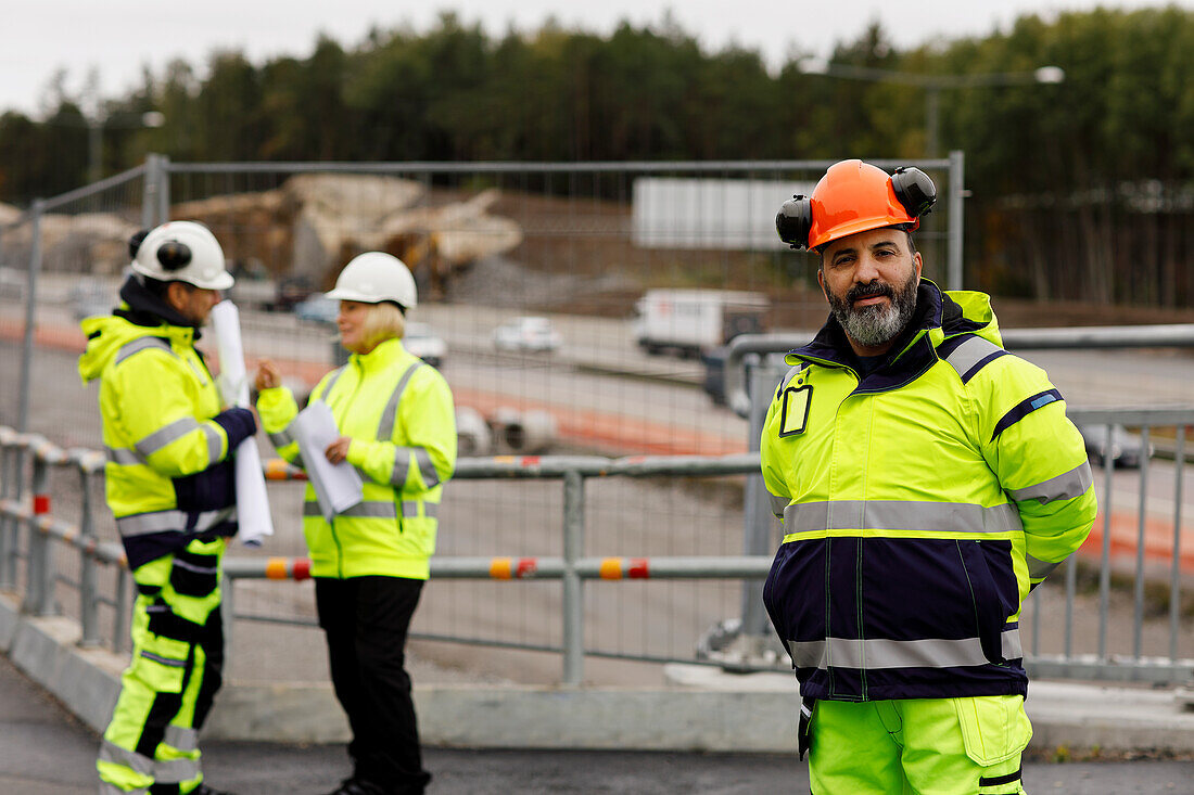 Ingenieure in reflektierender Kleidung auf der Baustelle