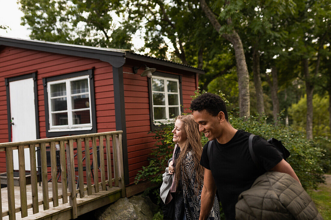 Smiling couple at wooden cabin