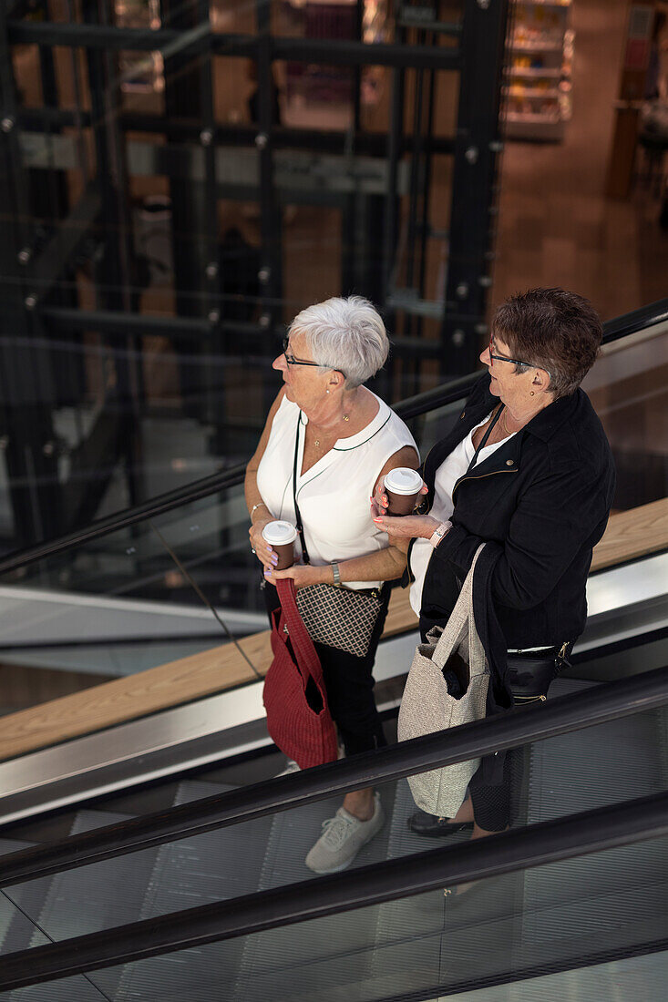 Frauen auf Rolltreppe, hoher Blickwinkel