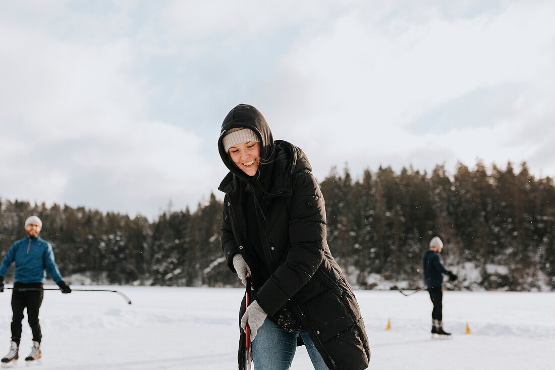Woman playing hockey on frozen lake