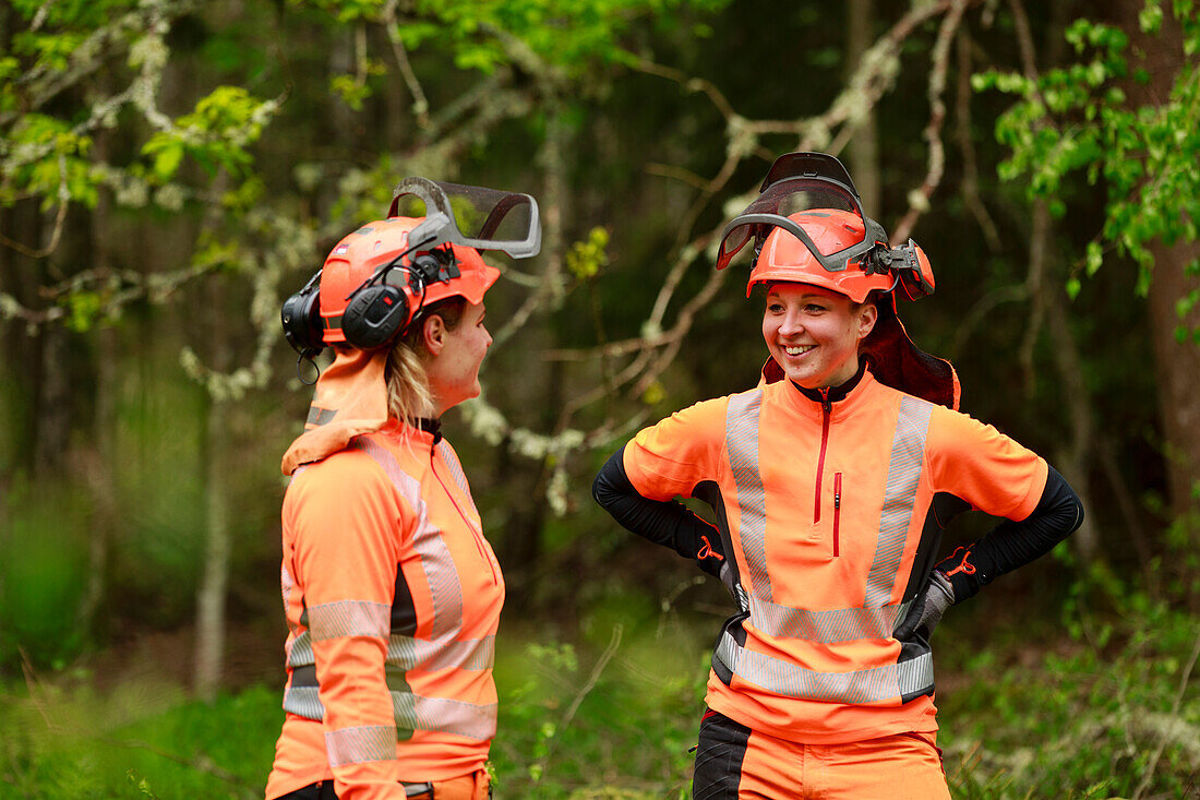 Lächelnde Holzfällerinnen im Wald