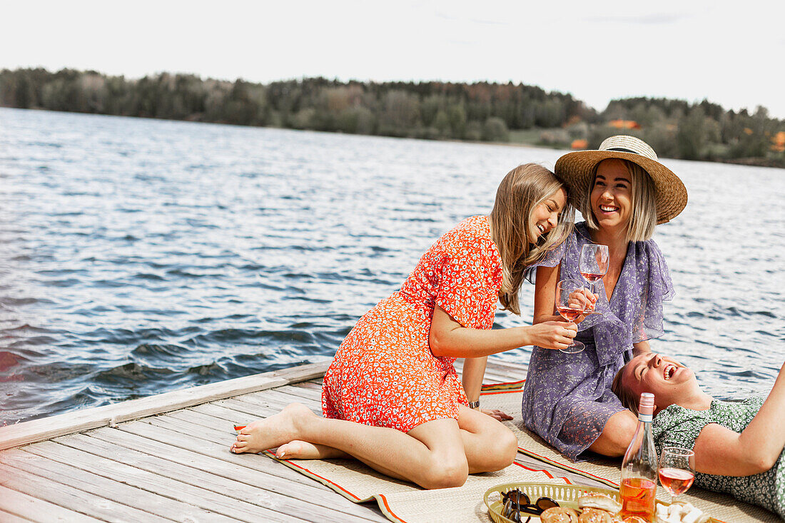 Female friends having picnic on jetty