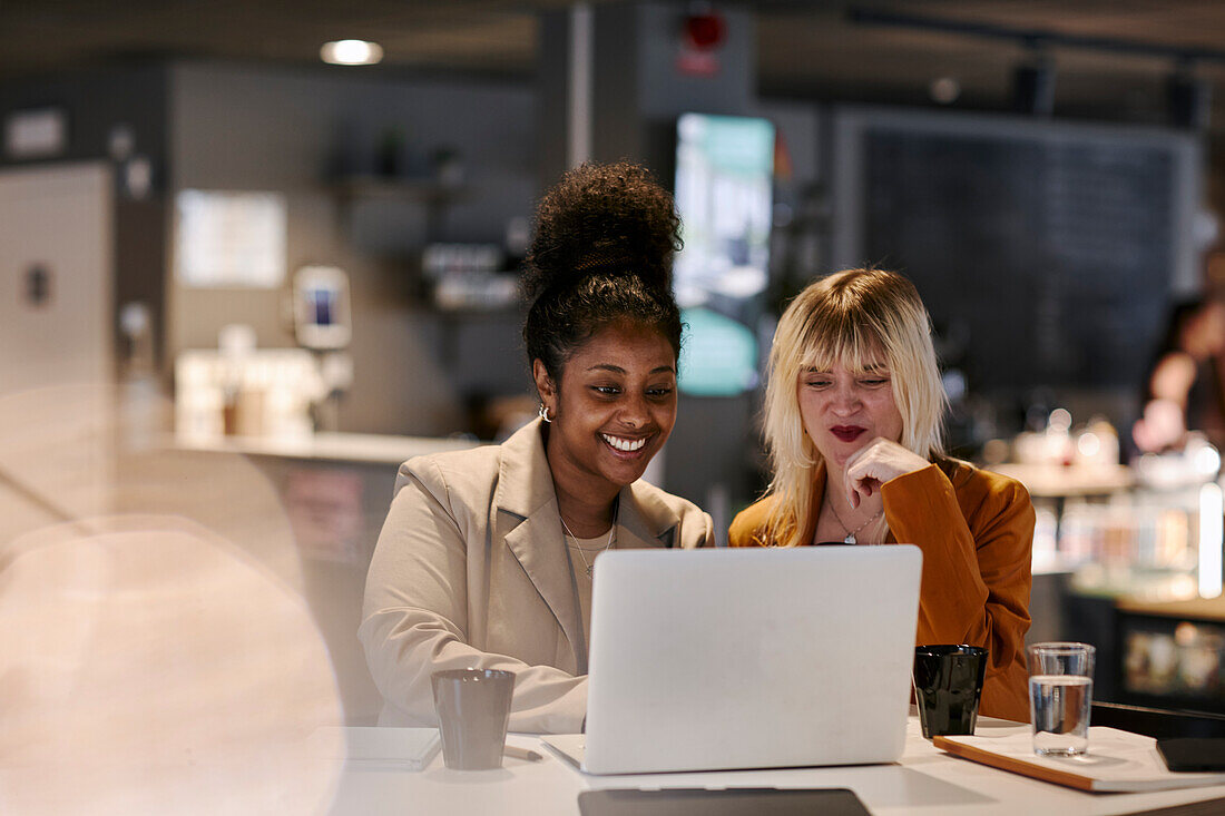 Weibliche Coworker im Gespräch im Cafe