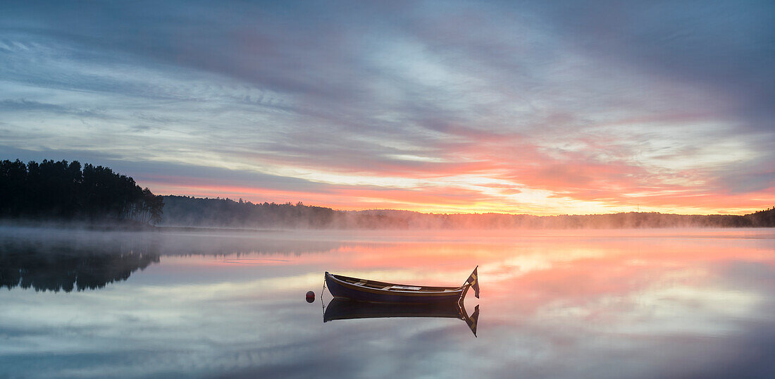 Boat in lake at sunrise