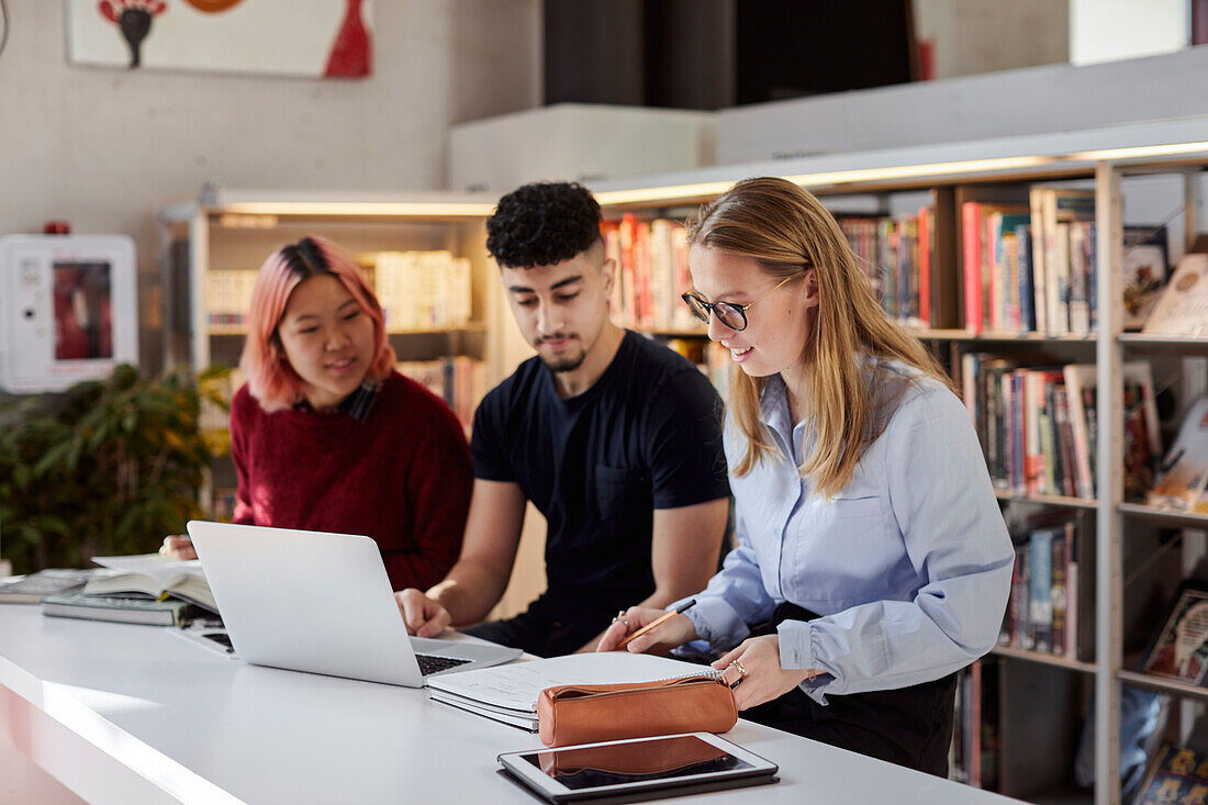 Gruppe von Studenten, die in der Bibliothek lernen