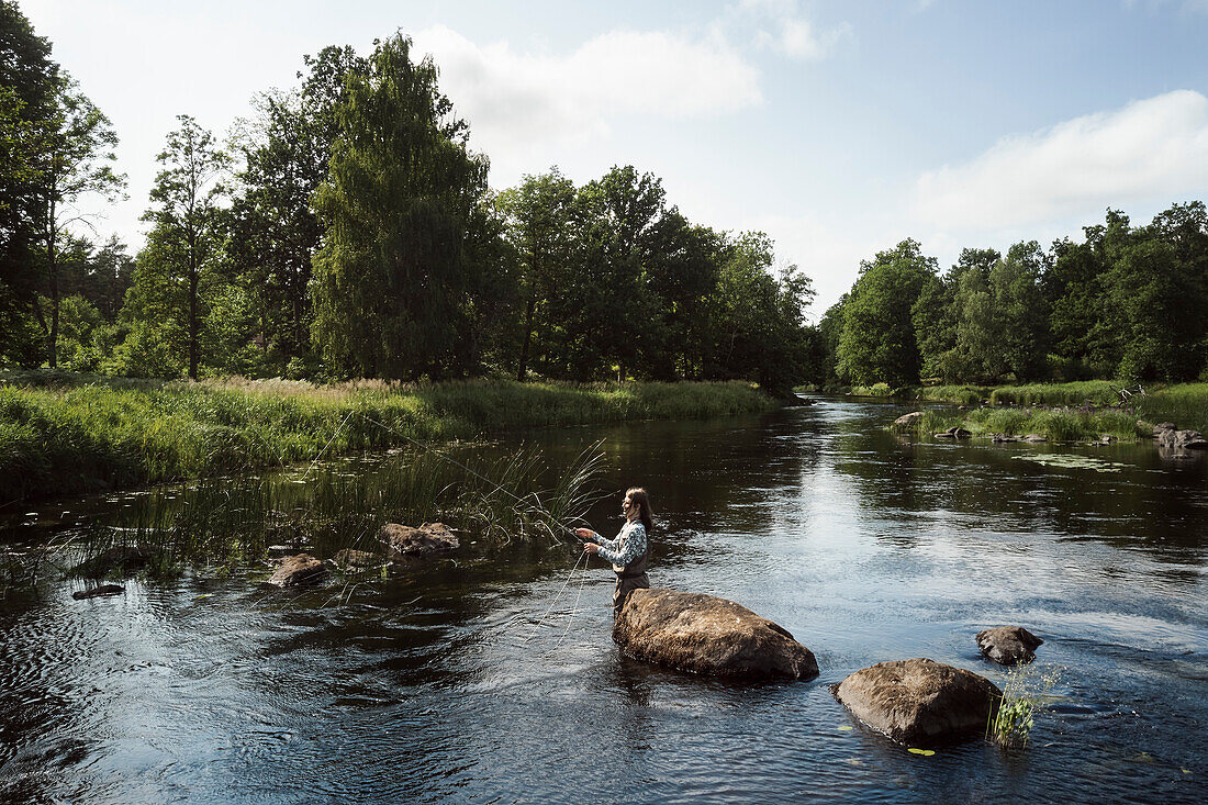 Woman fishing in river