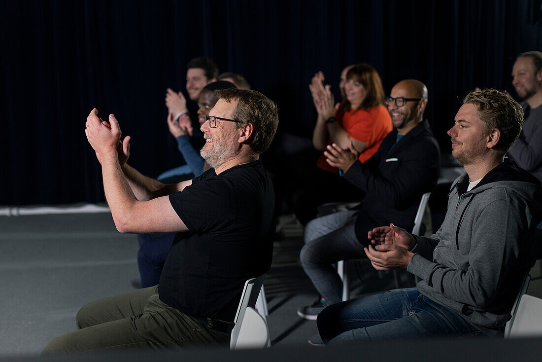 Smiling TV show audience clapping