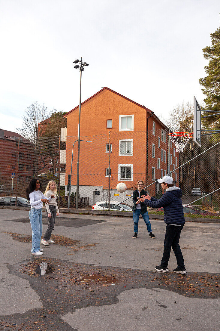 Freunde im Teenageralter spielen Basketball im Freien